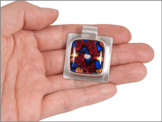 dichroic memory pendant shown in hand for size