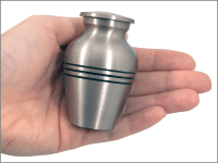 traditional brass small keepsake urn shown in hand for size comparison