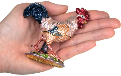 rooster cremation urn keepsake shown with hand for size scale
