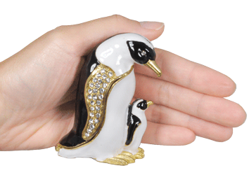 emperor penguins cremation urn keepsake shown with hand for size scale