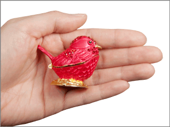 cardinal red bird cremation keepsake shown in hand for size scale