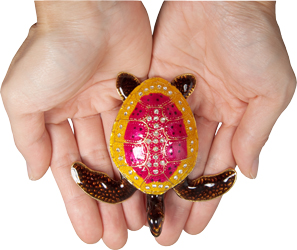 coral pink wholesale cremation turtle keepsake shown in hands