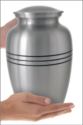 Traditional Pewter Cremation Urn shown in hand for size scale