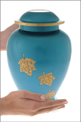 Falling Leaves Brass Cremation Urn shown in hands for size scale
