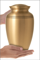 golden classic cremation urn shown in hands for size relation