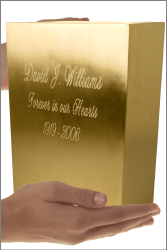 rectangular brushed brass urn shown in hands for size scale