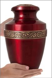 Scarlet Brass Cremation Urn shown in hands for size scale