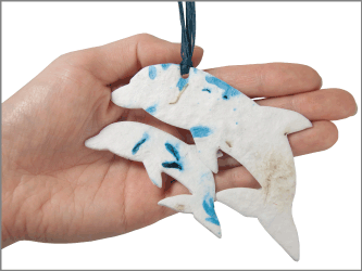 plantable memorials small and large dolphin shown in hand for size scale