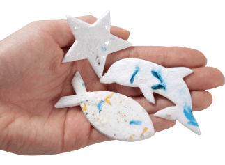 plantable memorials star, fish and dophin shapes shown in hand for size scale