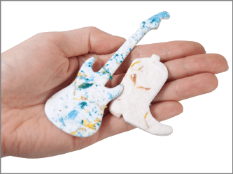 plantable memorials guitar and cowboy boot shapes shown in hand for size scale
